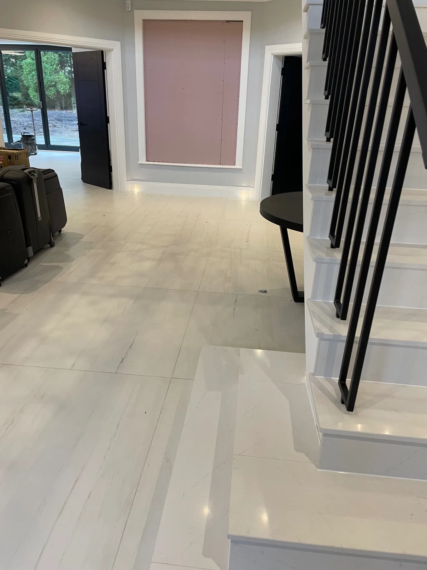 Polished marble-effect porcelain hallway with staircase and continuous joints