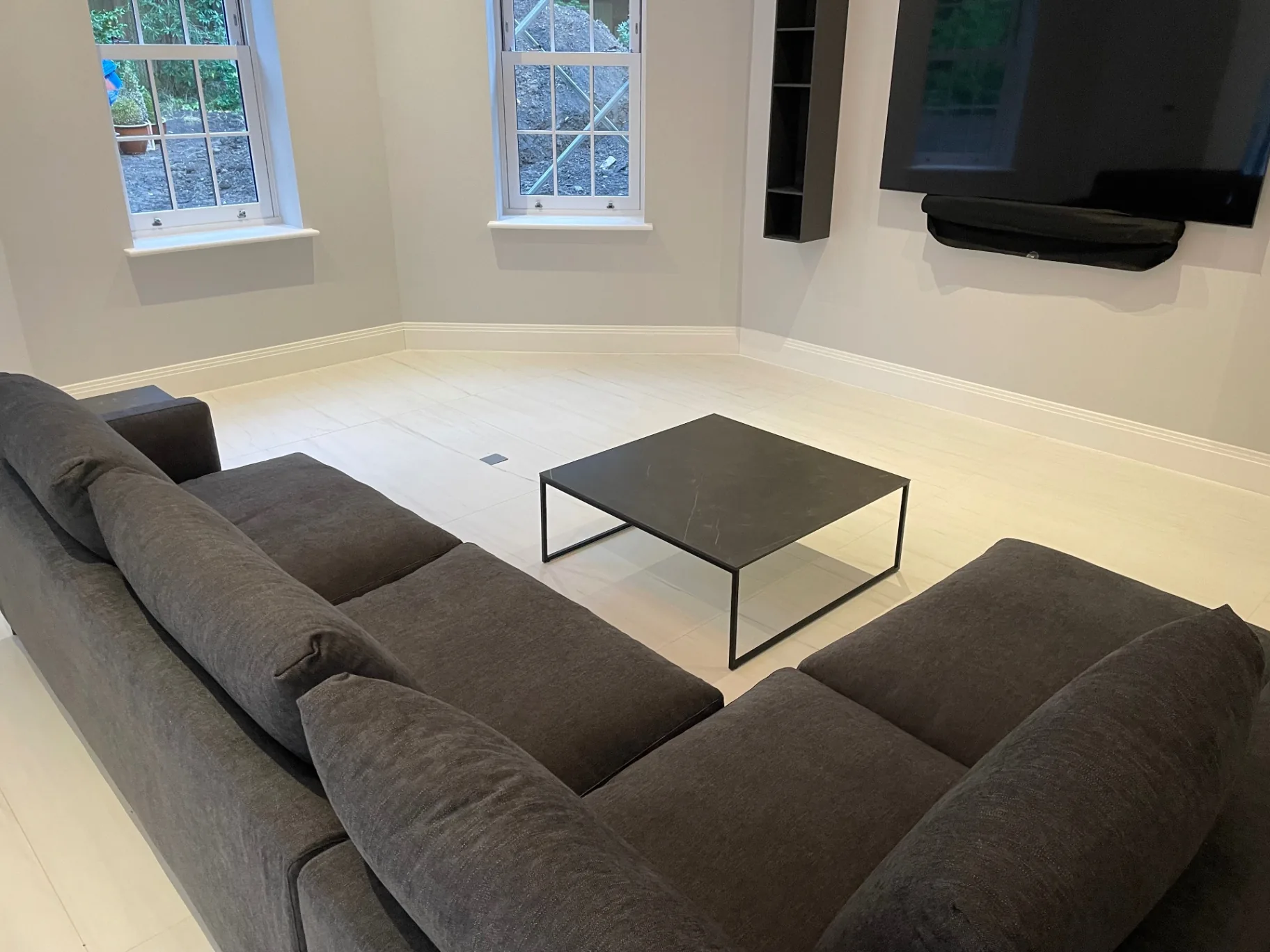 Large-format matte porcelain floor in a cinema lounge