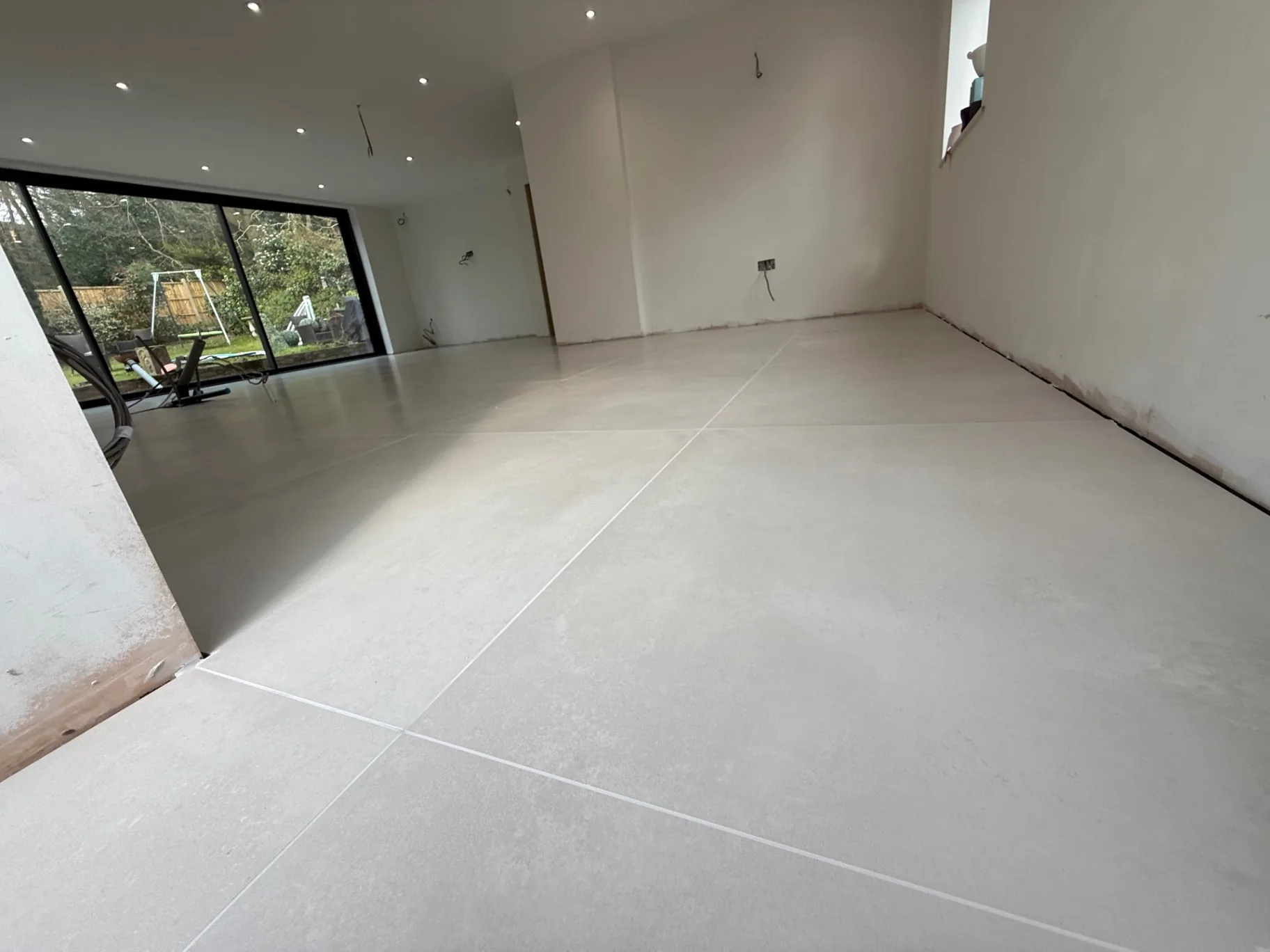 Large-format grey porcelain flooring across a new-build kitchen extension