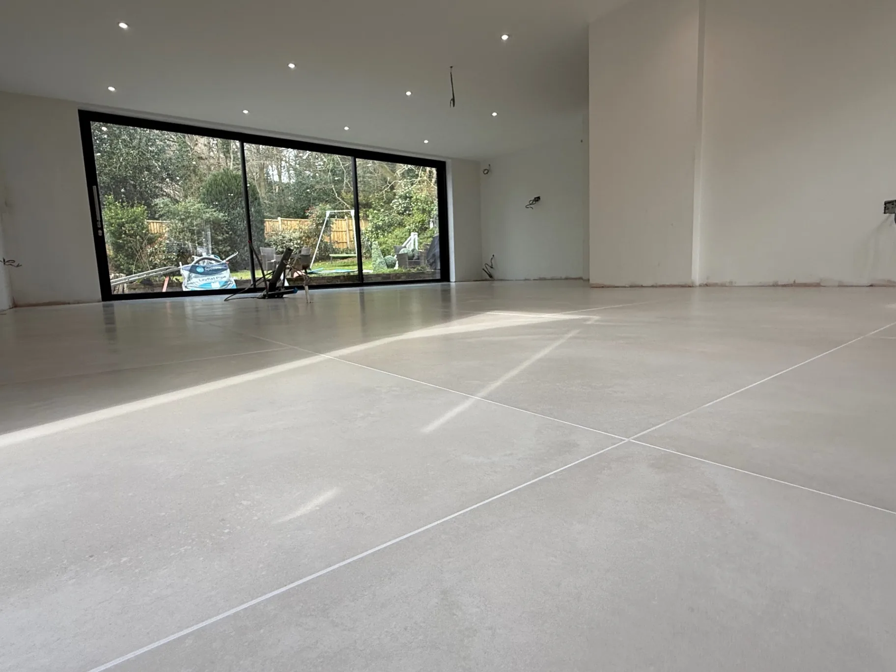 Raking daylight across the porcelain showing minimal lippage