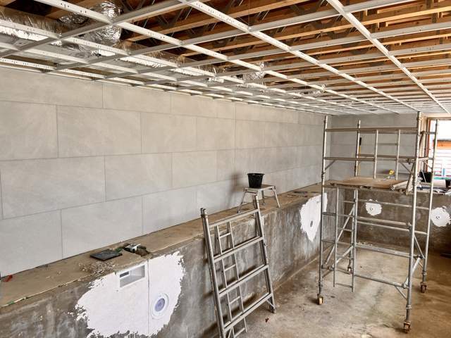 Pool hall walls during tiling, before the mosaic shell