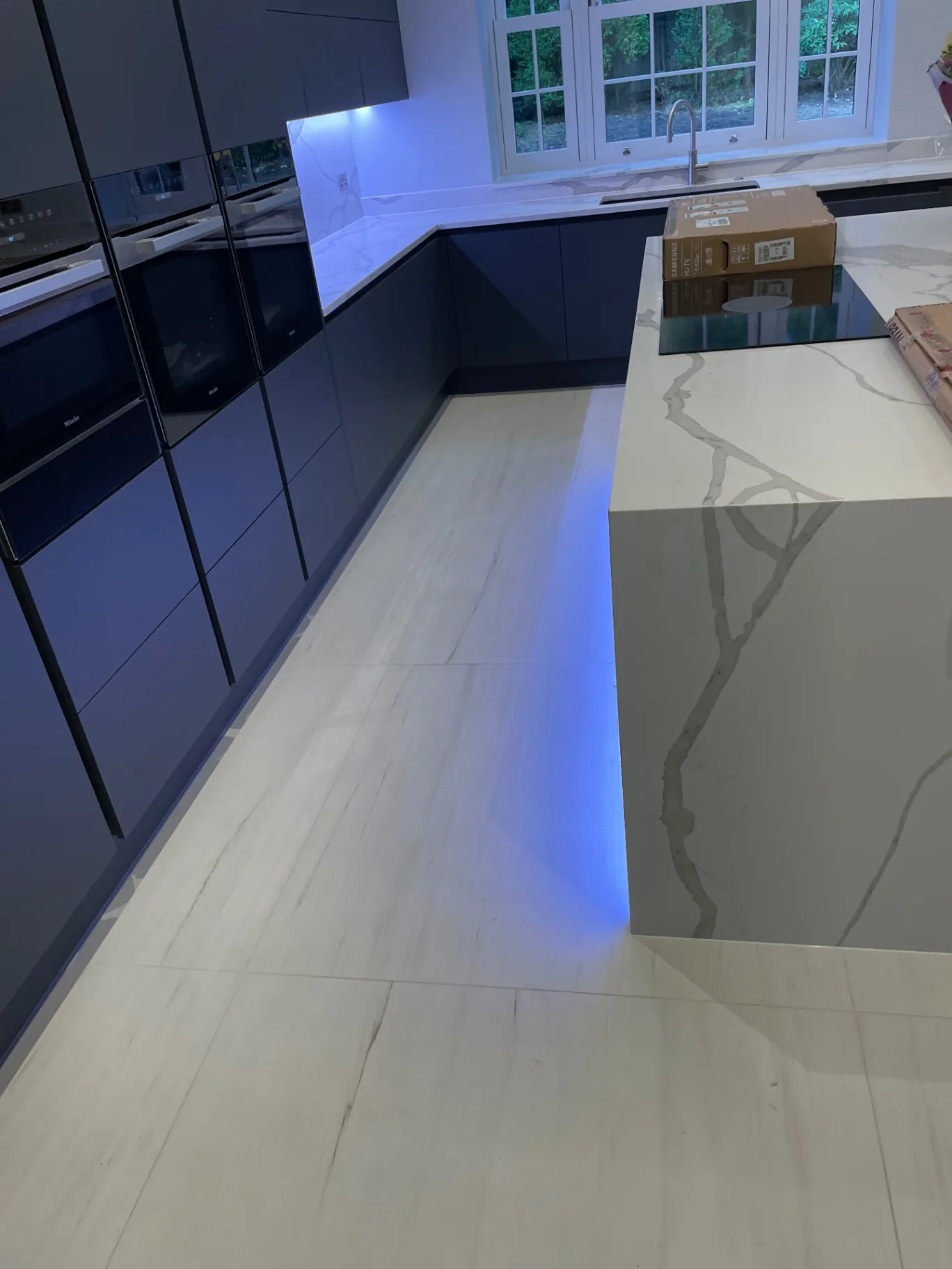 Polished porcelain meeting a Calacatta quartz kitchen island